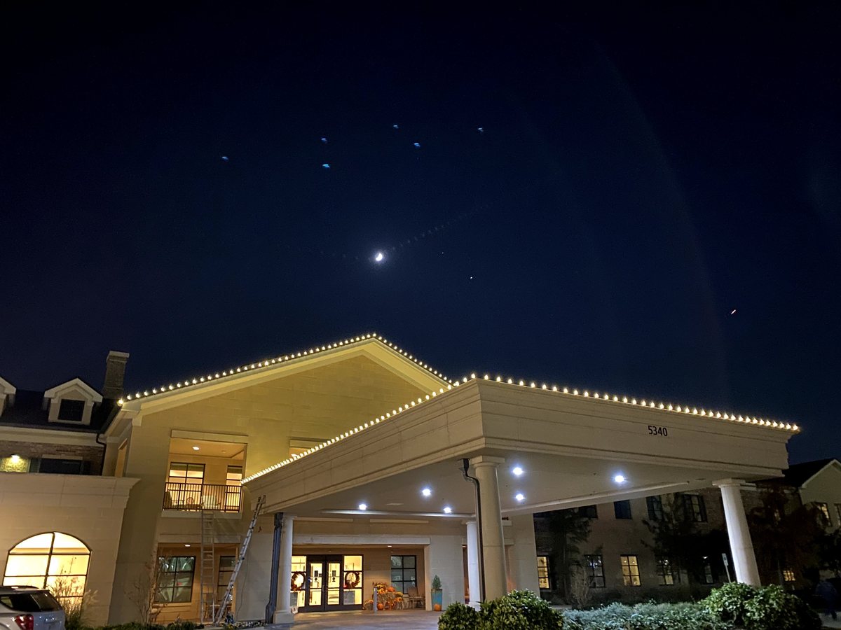 Commercial Christmas light installation DFW — warm white roofline lighting on a business building entrance