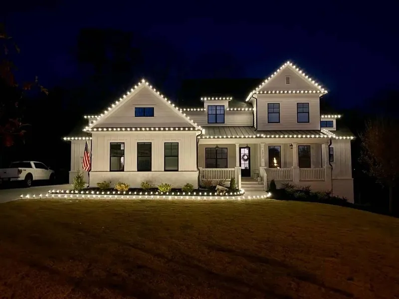 Christmas light installation Carrollton TX — warm white roofline and path lighting on a white home