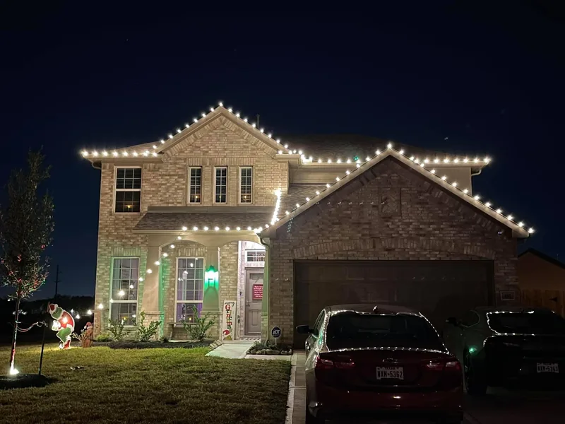 Christmas light installation Garland TX — multicolor roofline and lit arches on a brick home