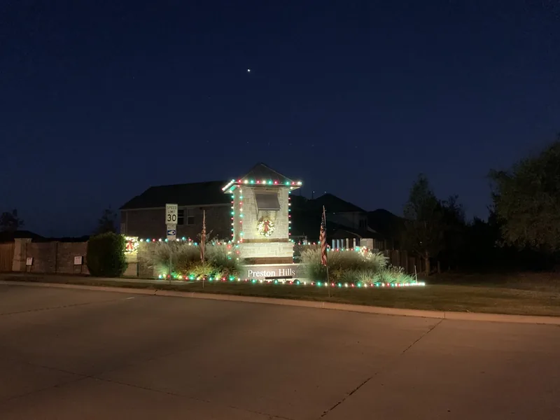 HOA Christmas light installation DFW โ warm white community entrance lighting at night