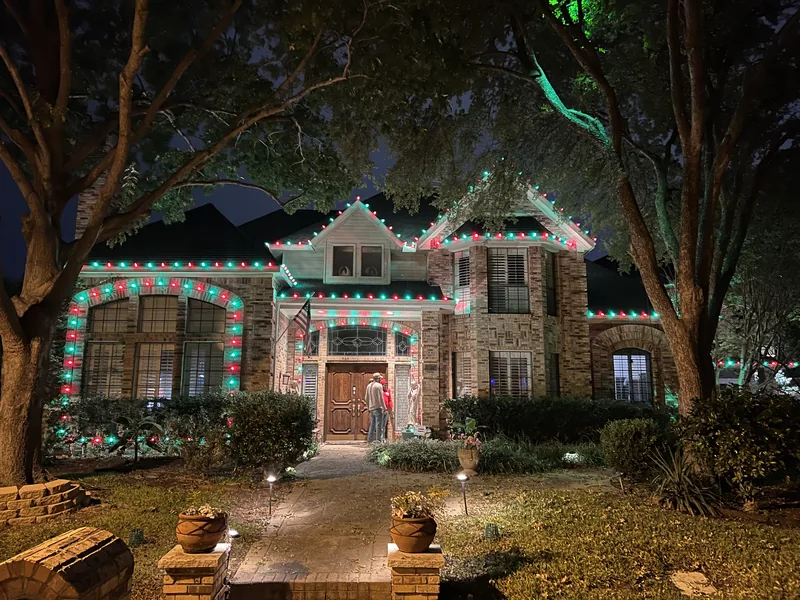Christmas light installation Murphy TX — red and green roofline lighting on a two-story brick home
