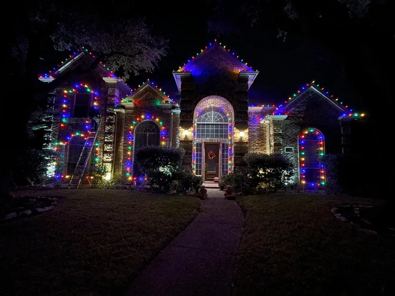 Christmas light installation Murphy TX — multicolor roofline and lit arches on a brick home