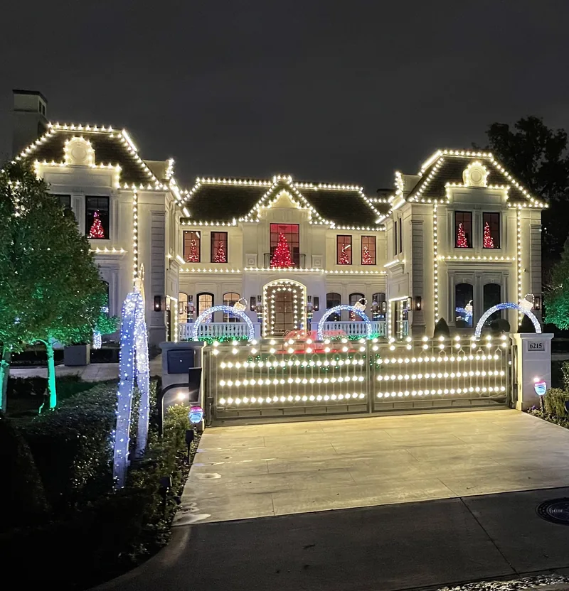 Warm white Christmas light roofline tracing the dome turret and arches of a Mediterranean estate in Trophy Club, TX